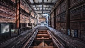 ra2盟军基地建设场景，兵营与战车工厂整齐排列，黄色矿石车往返运输资金
